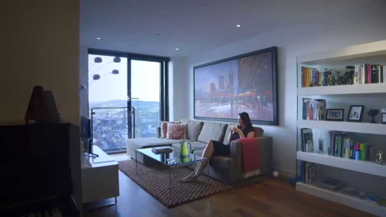 A woman seated in a modern living room with a green Vektra kettle on the coffee table.