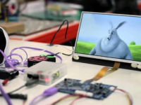 HDMIPi screen displaying an animation beside Raspberry Pi circuit boards and cables.