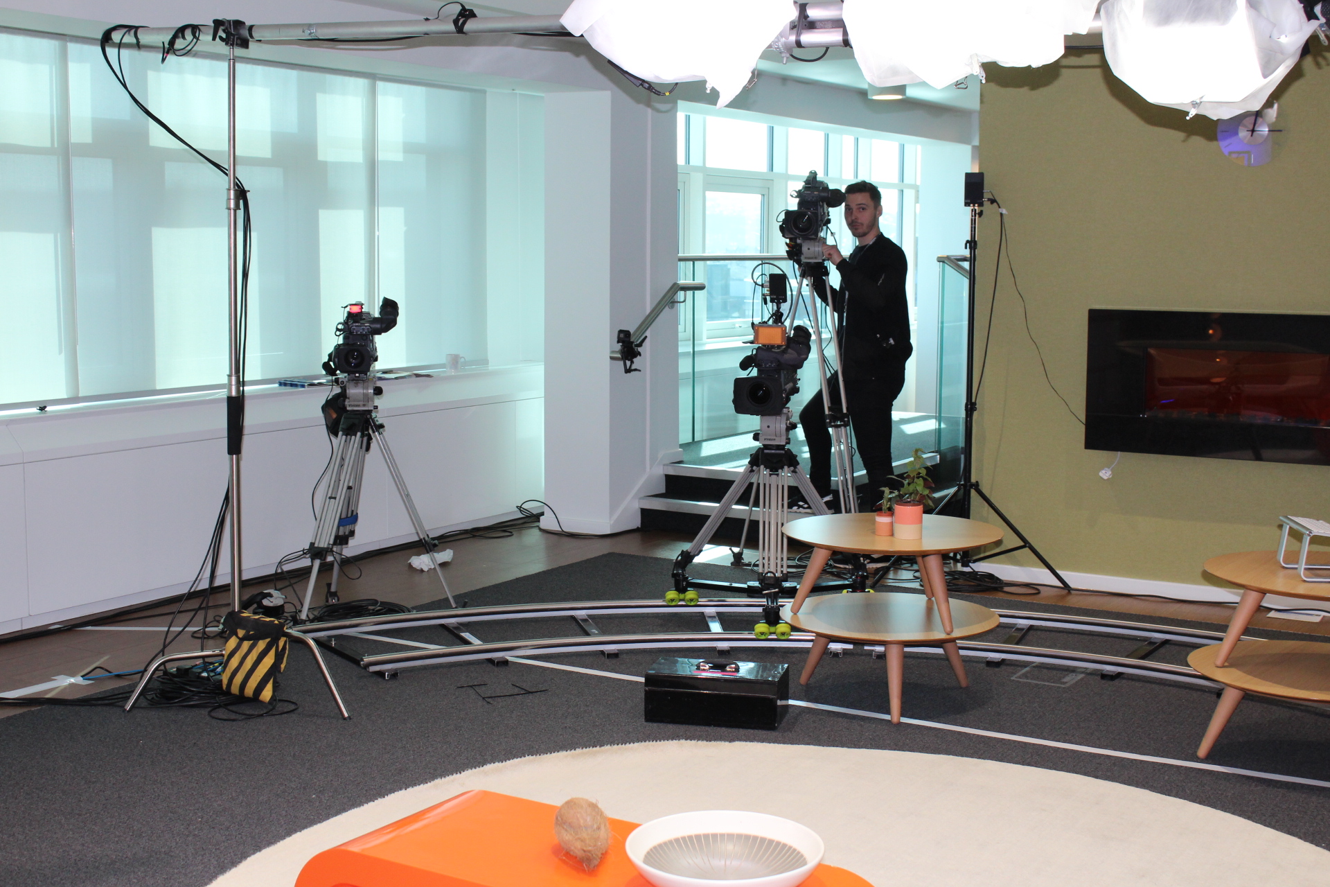 Four-camera production setup facing The Orange Table panel set