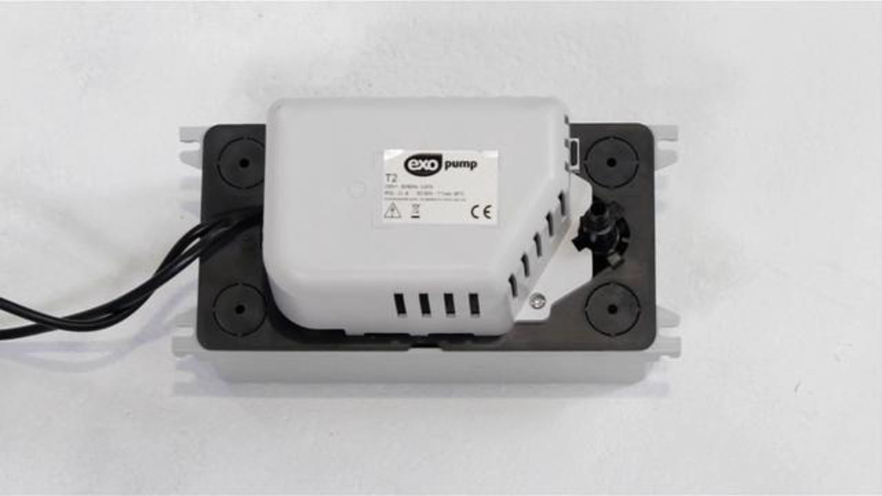 Exo Pump T2 unit mounted on its base with electrical cable and pipe connections visible.